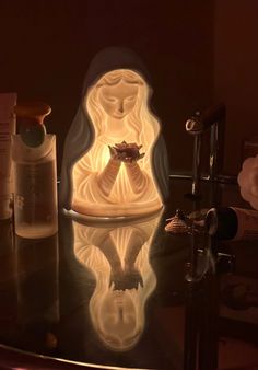 an illuminated buddha statue sitting on top of a table next to a bottle and soap dispenser