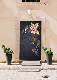 three potted cacti in front of a door with an artistic design on it