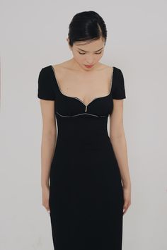 a woman in a black dress is looking down