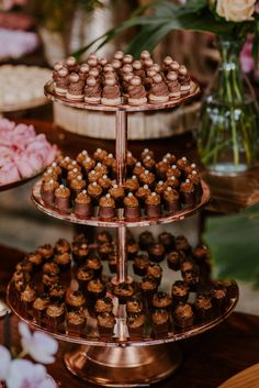 three tiered trays filled with cupcakes on top of a table