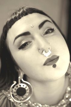 a woman with piercings on her nose and nose ring in front of her face