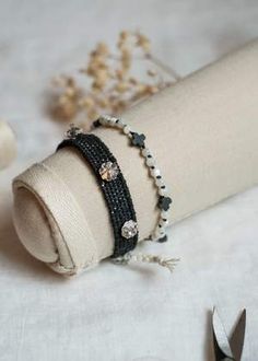 a pair of black beaded bracelets sitting on top of a piece of cloth