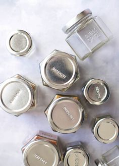 six different types of makeup on a white surface with the lids off and one is silver