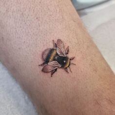 a small tattoo of a bee on the leg