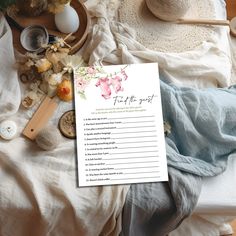 a table with flowers and other items on it, including a paper that says find the guest