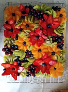 a square cake with fruit and flowers on it