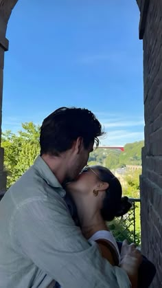 a man and woman kissing in an archway