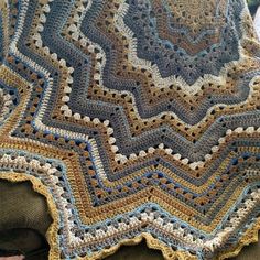 a crocheted blanket sitting on top of a couch