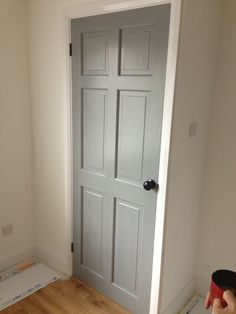 an open door with the words grey door, black knobs, and white surround