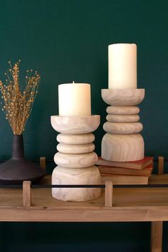 two candles sitting on top of a wooden table