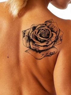 a woman with a rose tattoo on her back and shoulder, showing it's intricate design