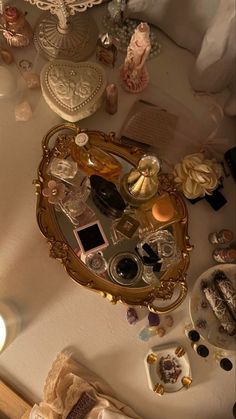 there is a mirror on the table with many items around it and candles in front of it