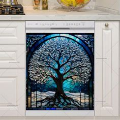 an image of a stained glass tree in the middle of a kitchen countertop with white cabinets