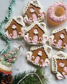 decorated gingerbread cookies with icing and sprinkles on a white table