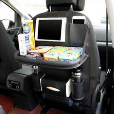 the back seat of a car with snacks and drinks on it's trays