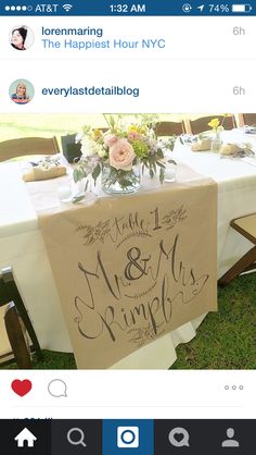 the table is set up for an event with flowers in vases on it and a sign that says happily married and mr & mrs