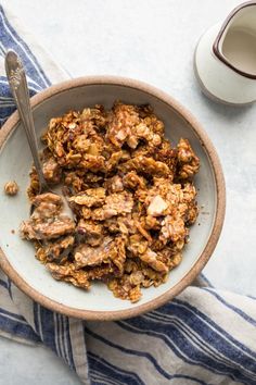 a bowl filled with granola next to a cup of coffee