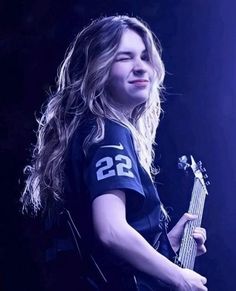 a woman with long hair holding a guitar