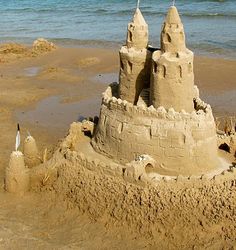 a sand castle sitting on top of a sandy beach