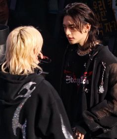 two people standing next to each other talking