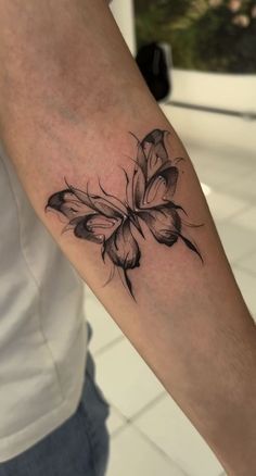 a black and white butterfly tattoo on the arm