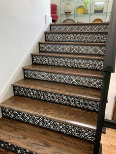 a set of stairs with decorative handrails and wood flooring in a home