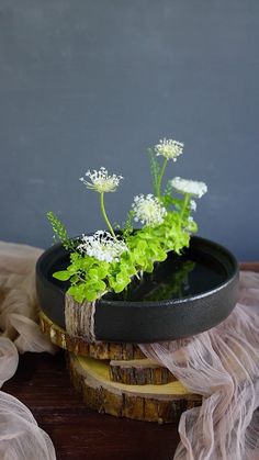 some white flowers are in a black bowl