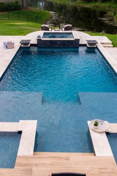 an outdoor swimming pool with lounge chairs around it