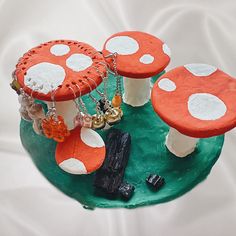 three orange and white mushrooms sitting on top of a green plate with chains hanging from them