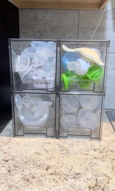 three plastic containers with various items in them sitting on a counter next to a sink