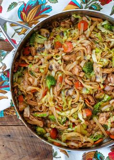 a pan filled with noodles and vegetables on top of a table