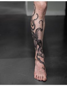 a man's legs with an octopus tattoo on the bottom part of his leg