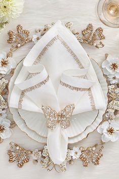 a table setting with white and gold decorations