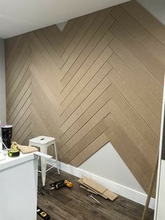 an unfinished room with wood paneling on the wall and construction tools scattered around it