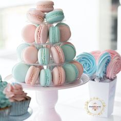 there are many different types of macaroons on the cake stand and cupcakes