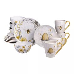 a set of dishes and cups with bees on them, including one for the dinner table