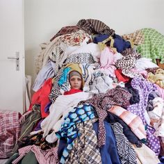 a pile of clothes sitting on top of a bed