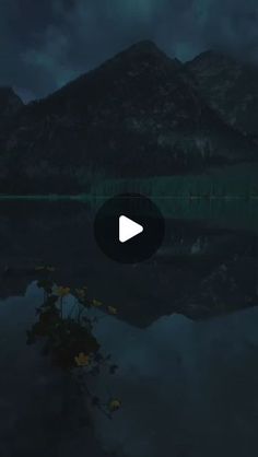 a video player is playing on the screen in front of a mountain lake at night