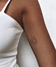 a woman with a small sun tattoo on her arm