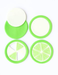 four slices of lime cut in half on a white surface with green and white accents