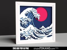 an origami art piece depicting the great wave in blue and pink with red sun behind it