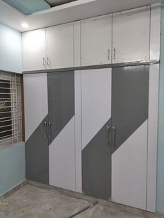 an empty room with several white and grey cupboards