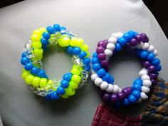 two bracelets sitting on top of a pillow next to each other, one in different colors