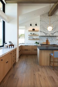 a kitchen with wooden cabinets and marble counter tops, along with an island in the middle