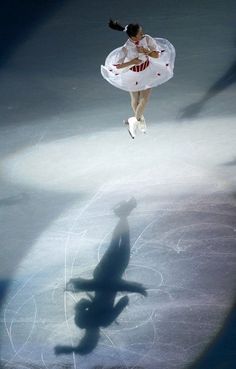 a woman in white dress skating on ice