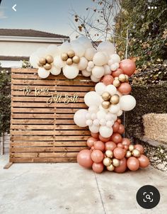 a large balloon arch with gold and white balloons