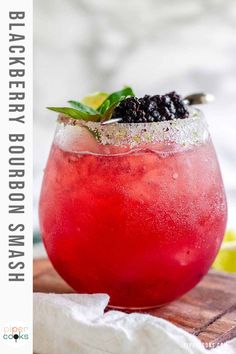 the blackberry bourbon smash cocktail is garnished with fresh blackberries and limes