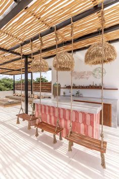 an outdoor bar with benches and straw umbrellas