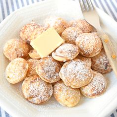 powdered sugar covered pastries and butter on a plate