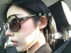 a woman wearing sunglasses sitting in the back seat of a car with her head up